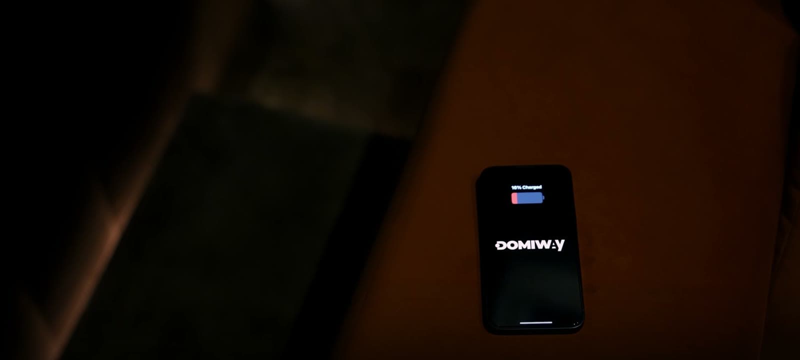 Carregamento sem fios de telemóvel no sofá do showroom DOMIWAY.